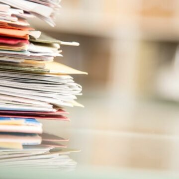 A stack of documents on a desk to help illustrate this blog on fact finding hearings.