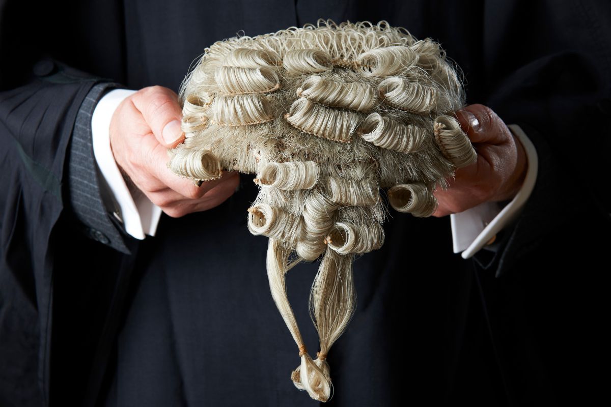 A barrister clutching his white wig in his hands to help illustrate Barristers First's blog answering the question, 'what is a direct access barrister?'.